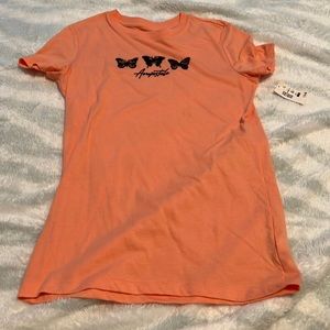 This is a brand new shirt it is a salmon color the words on the front are black